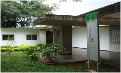 Fotografia da fachada do prédio da Gerência de Metrologia das Radiações e seu jardim frontal verdejante.